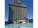 Relaxing pool with lounge chairs and a high-rise condominium in a tropical setting at 13427 Blue Heron Beach Dr # 1802, Orlando, FL 32821