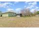 Grassy backyard featuring patio, mature tree, and shed at 14325 Golden View Dr, Grand Island, FL 32735