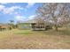 Backyard featuring a mature tree, green lawn, and enclosed patio at 14325 Golden View Dr, Grand Island, FL 32735
