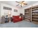 Comfortable bonus room features a red sofa, window, and wooden shelving units at 14325 Golden View Dr, Grand Island, FL 32735