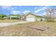 Green one-story home showing side and garage, with a well-maintained lawn at 14325 Golden View Dr, Grand Island, FL 32735
