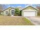 Charming green one-story home with a well-maintained lawn and attached two-car garage at 14325 Golden View Dr, Grand Island, FL 32735