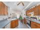 Kitchen with wooden cabinets, appliances and breakfast bar and view into eat-in nook at 14325 Golden View Dr, Grand Island, FL 32735