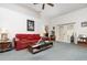 Comfortable living room with a red sofa, ceiling fan, and a sliding glass door at 14325 Golden View Dr, Grand Island, FL 32735