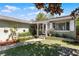 Beautifully landscaped front yard with a covered porch and a white door at 1564 Cavendish Rd, Winter Park, FL 32789