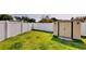 Fenced backyard with lush green grass, white privacy fence and storage shed at 193 Lansbrook Ct, Ocoee, FL 34761