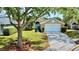 Charming single-story home with a well-manicured lawn, mature tree, and an attached two-car garage at 193 Lansbrook Ct, Ocoee, FL 34761