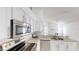 Well-lit kitchen featuring stainless steel appliances, granite countertops, and sleek white cabinets at 193 Lansbrook Ct, Ocoee, FL 34761