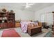 This bedroom features a floral bedspread, a ceiling fan, and ample storage with a large bookcase at 20705 Nettleton St, Orlando, FL 32833