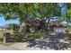 Brick home featuring a well-manicured lawn and a large tree providing substantial shade coverage at 20705 Nettleton St, Orlando, FL 32833