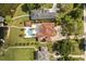 Aerial view of a luxury home featuring a terracotta roof, pool with patio, and landscaped grounds at 225 Magnolia St, Windermere, FL 34786
