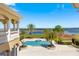 Lush backyard featuring a sparkling pool, well-manicured lawn, mature palm trees and lake views at 225 Magnolia St, Windermere, FL 34786