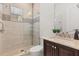 Beautiful bathroom with dark wood vanity, stone countertops, and glass-enclosed shower with built-in shelving at 225 Magnolia St, Windermere, FL 34786