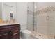 Bathroom with dark wood cabinets, marble countertops, and a glass-enclosed shower with mosaic tile accents at 225 Magnolia St, Windermere, FL 34786