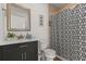 Modern bathroom design with black vanity, wood accent wall, framed mirror and designer shower curtain at 225 Magnolia St, Windermere, FL 34786