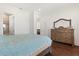 Bright bedroom with wood floors, dresser, and a view to the stairs and bathroom at 225 Magnolia St, Windermere, FL 34786