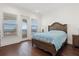 Bedroom boasts wood floors and a balcony with a view of the water at 225 Magnolia St, Windermere, FL 34786