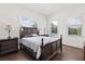 Comfortable bedroom featuring a wooden bed frame, matching nightstands, and natural light through the windows at 225 Magnolia St, Windermere, FL 34786