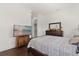 Cozy bedroom with dark wood floors, neutral walls, dresser, and large screen television at 225 Magnolia St, Windermere, FL 34786