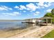 Sandy beach leads to a pier with boat dock and gazebo on the lake at 225 Magnolia St, Windermere, FL 34786