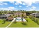 Aerial view of a home with an outdoor pool, patio, lush lawn and mature palm trees at 225 Magnolia St, Windermere, FL 34786