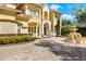 Beautiful Mediterranean-style home with a brick driveway, a fountain and manicured landscaping in the front yard at 225 Magnolia St, Windermere, FL 34786