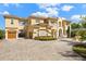 Stunning Mediterranean-style home showcasing a tile roof, balconies, porte-cochere and a brick paver driveway at 225 Magnolia St, Windermere, FL 34786