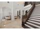 Airy foyer boasting a staircase with dark wood railings, marble floors, and open access to living spaces at 225 Magnolia St, Windermere, FL 34786