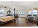 Bright main bedroom boasts a four-poster bed, hardwood floors, and a charming breakfast nook with stunning water views at 225 Magnolia St, Windermere, FL 34786