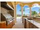 Built-in outdoor kitchen with stainless steel grill, sink, prep area, and lake views at 225 Magnolia St, Windermere, FL 34786