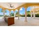 Covered outdoor kitchen features counter seating, sink, stainless steel appliances, and water views at 225 Magnolia St, Windermere, FL 34786