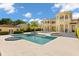 Backyard oasis featuring a pool, spa, palm trees, and a large luxury home with balconies at 225 Magnolia St, Windermere, FL 34786