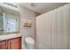 This bathroom features a tiled floor and shower, toilet and vanity with granite counters at 225 W Seminole Blvd # 409, Sanford, FL 32771