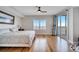 Bright bedroom with hardwood floors, balcony access, and large windows with shutter blinds at 225 W Seminole Blvd # 409, Sanford, FL 32771