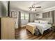 Bedroom with wood floors, ceiling fan, large window, dresser, and TV at 2601 Windward Ct, Orlando, FL 32805