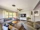 Cozy living room with hardwood floors, neutral colors, a ceiling fan and a large television at 2601 Windward Ct, Orlando, FL 32805