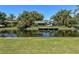 Back view of the house on a canal, with dock, lush foliage, and blue sky at 2601 Windward Ct, Orlando, FL 32805