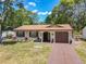 Charming, one-story home with a brick exterior, front lawn, and a driveway leading to an attached garage at 2617 S Marshall Ave, Sanford, FL 32773