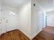 Clean, freshly painted hallway with wood-look vinyl floors that lead to a bathroom and a door with a window at 2617 S Marshall Ave, Sanford, FL 32773