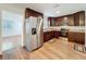 A kitchen featuring stainless steel appliances, dark cabinets, granite countertops, and wood-look flooring at 2617 S Marshall Ave, Sanford, FL 32773