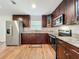 A kitchen area featuring stainless steel appliances, dark cabinets, and granite countertops at 2617 S Marshall Ave, Sanford, FL 32773