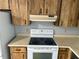 Kitchen with wooden cabinets and white appliances, including a range with a hood, offering practical cooking space at 2618 Adela Ave, Orlando, FL 32826