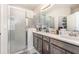 Bathroom featuring double sinks, gray cabinets, and glass shower at 2865 High Pointe St, Clermont, FL 34711