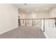 Open loft area with neutral carpet, white railing, and overhead lighting at 2865 High Pointe St, Clermont, FL 34711