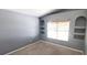 Cozy bedroom showcasing built-in display shelves, neutral walls, carpeted floor, and a window at 3131 Effingham Dr, Clermont, FL 34714