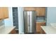 Kitchen featuring stainless steel refrigerator, wood cabinets, and an open pantry next to a breakfast bar at 3131 Effingham Dr, Clermont, FL 34714