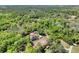 Aerial view showcases a home, equestrian paddock, barn, and surrounding verdant woodlands at 3149 Scrub Oak Trl, Oviedo, FL 32765