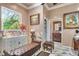 Elegant bathroom featuring marble floors, a vanity with fresh flowers, and a tufted bench at 3149 Scrub Oak Trl, Oviedo, FL 32765