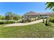 Home exterior with a lush lawn, garden, and a driveway leading to a carport at 3149 Scrub Oak Trl, Oviedo, FL 32765