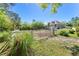 Exterior view of house and paddock with lush greenery, white fencing and a metal gate at 3149 Scrub Oak Trl, Oviedo, FL 32765
